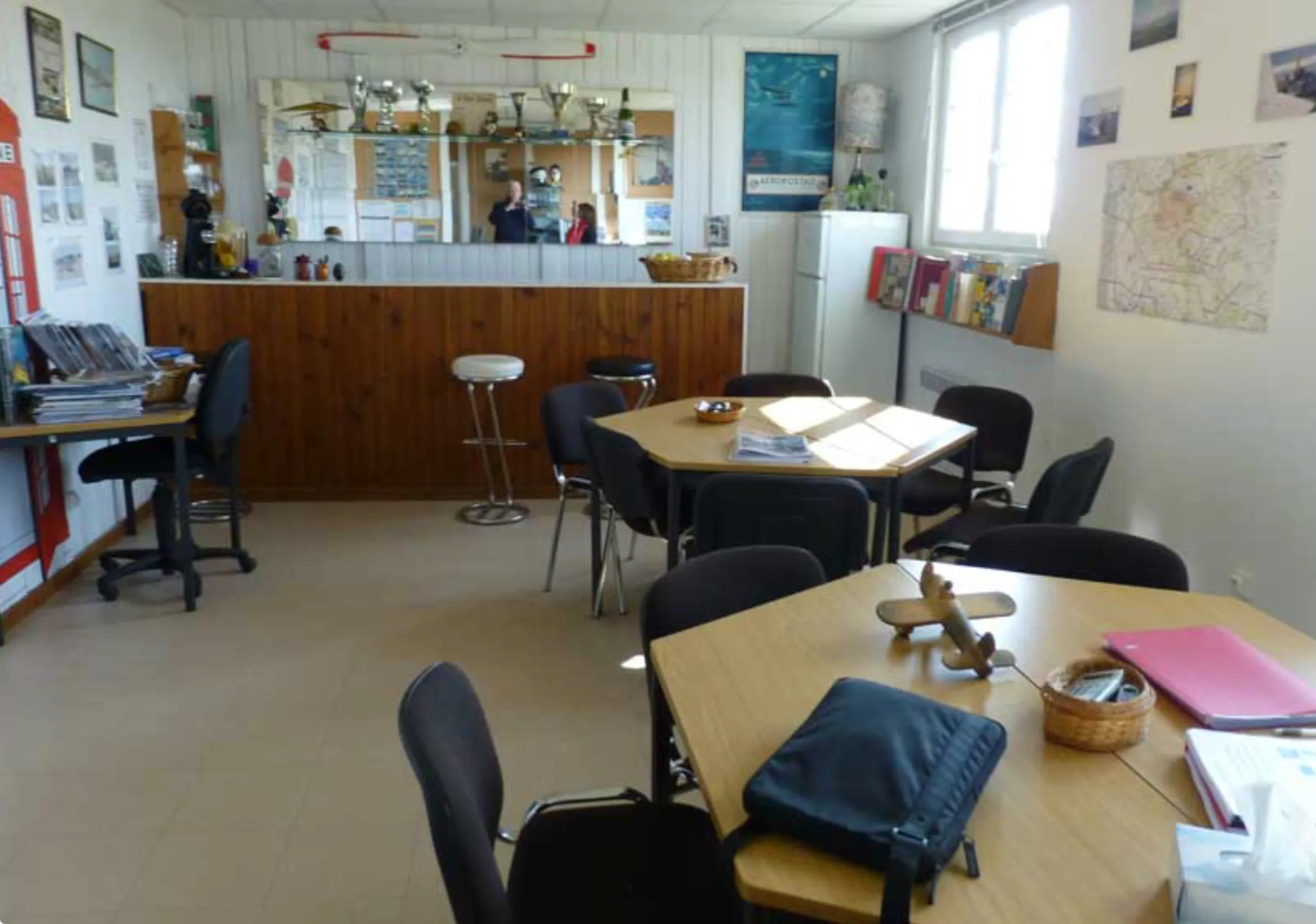La salle du club, avec son bar, ses tables et ses cartes au mur